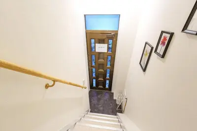a hallway with stairs leading up to a door at \u6953\u5c4b\u30a2\u30cd\u30c3\u30af\u30b9 120Tb in Tokyo
