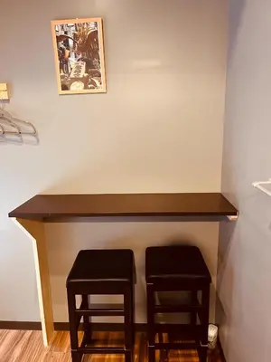 a table with two stools under a wall at Mikami Asakusabashi Hotel in Tokyo