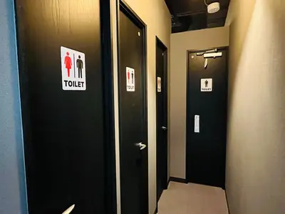 a hallway with two black doors with signs on them at Mikami Asakusabashi Hotel in Tokyo