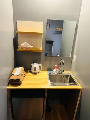 a kitchen counter with a sink and a mirror at Mikami Asakusabashi Hotel in Tokyo