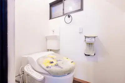 a white bathroom with a toilet with a flower seat at \u5927\u718a\u306e\u5bb6 028t in Tokyo