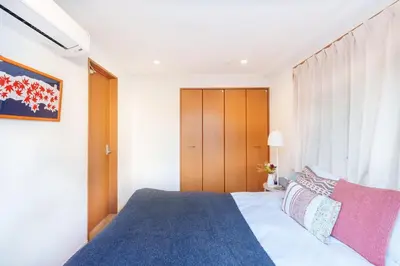 a bedroom with a large bed with a blue blanket at MINE HOME\u91ce\u65b9 121t in Tokyo