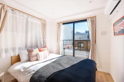 a bedroom with a bed and a large window at MINE HOME\u91ce\u65b9 121t in Tokyo