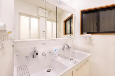 a white bathroom with a sink and a mirror at MINE HOME\u91ce\u65b9 121t in Tokyo