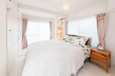 a white bedroom with a large bed and windows at \u697d\u5bbfSUMIDA 002t in Tokyo