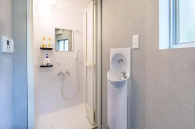 a white bathroom with a shower and a sink at Y's INN 押上 115T in Tokyo