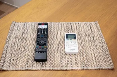 two remote controls sitting on top of a table at 132T close \u5922\u306e\u5bbf \u7ffc in Tokyo