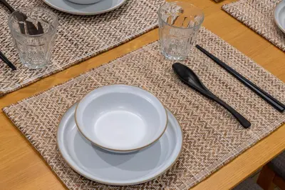 a table with a white plate and two glasses and chopsticks at 132T close \u5922\u306e\u5bbf \u7ffc in Tokyo