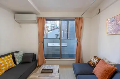 a living room with a couch and a large window at 132T close \u5922\u306e\u5bbf \u7ffc in Tokyo