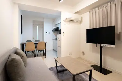 a living room with a couch and a tv and a table at \u30a2\u30fc\u30d0\u30f3\u30b3\u30fc\u30c8\u62bc\u4e0a in Tokyo