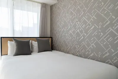 a bedroom with a white bed and a window at \u30a2\u30fc\u30d0\u30f3\u30b3\u30fc\u30c8\u62bc\u4e0a in Tokyo