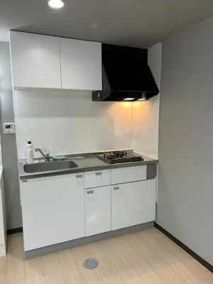 a white kitchen with a sink and a stove at Haneda Base in Tokyo