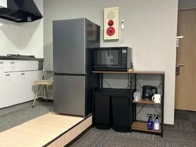 a kitchen with a refrigerator and a microwave at Haneda Base in Tokyo