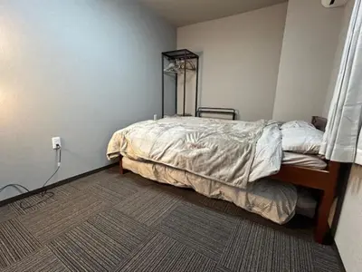 a bedroom with a bed in the corner of a room at Haneda Base in Tokyo