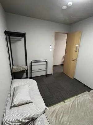 an empty room with two beds and a door at Haneda Base in Tokyo