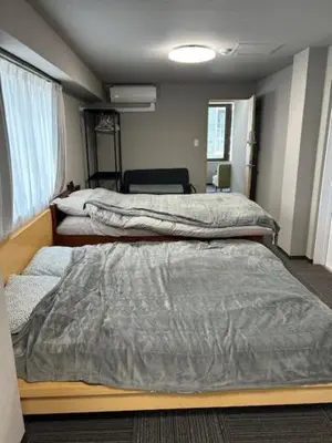 a bedroom with two beds and a window at Haneda Base in Tokyo