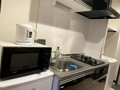 a small kitchen with a sink and a microwave at \u7af9\u30ce\u585a \u30d7\u30ec\u30df\u30a2 in Tokyo