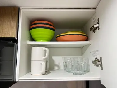 a white cabinet with bowls and plates in it at jtr\u6d45\u8349\u6a4b302 in Tokyo