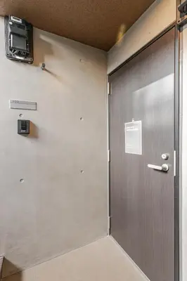 a metal door in a room with a wall at jtr\u6d45\u8349\u6a4b302 in Tokyo