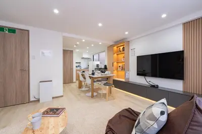 a living room with a couch and a table with a television at Y's INN 駒込 110T in Tokyo
