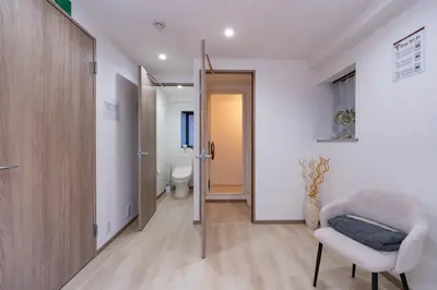 a hallway with a toilet and a chair in a room at Y's INN 駒込 110T in Tokyo