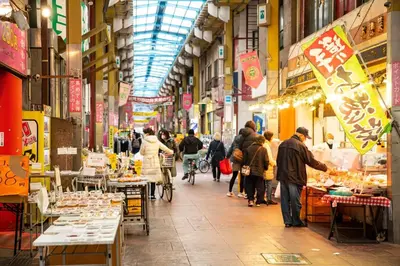 a group of people walking through a market at \u4e09\u30ce\u8f2a101 in Tokyo