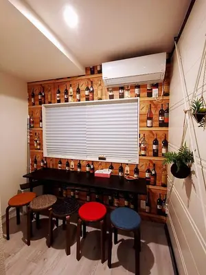 a room with stools and a wall with bottles at \u4e09\u30ce\u8f2a401 in Tokyo