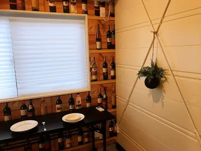 a bathroom with two sinks and a wall of wine bottles at \u4e09\u30ce\u8f2a401 in Tokyo