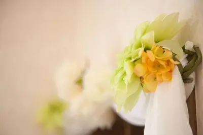 a white vase with green and yellow flowers in it at \u697d\u5bbf \u58a8\u7530II 003t in Tokyo