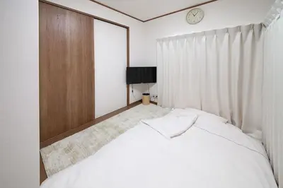a bedroom with a bed and a clock on the wall at \u697d\u5bbf \u58a8\u7530II 003t in Tokyo