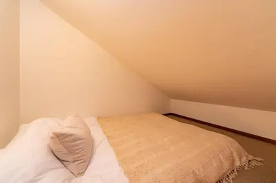 a small bedroom with a bed with white sheets at \u512a\u697d\u82d1 113t in Tokyo