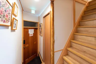 a hallway with stairs and a wooden door at \u697d\u9038 026t in Tokyo