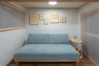 a bedroom with a bed with blue sheets and a table at \u697d\u9038 026t in Tokyo
