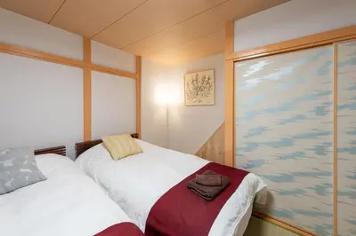 a bedroom with two beds and a large window at \u697d\u9038 026t in Tokyo