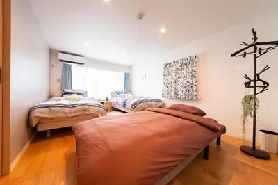 a room with two beds and a couch in it at \u697d\u5bbf \u4e2d\u4e95 004t in Tokyo