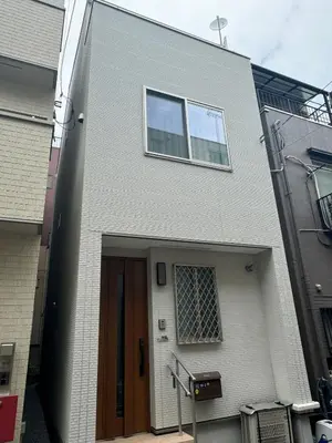 a white brick building with a door and a window at \u53f0\u4e1c\u533a\u677e\u8c37 in Tokyo
