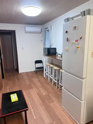 a kitchen with a white refrigerator and a table at \u53f0\u4e1c\u533a\u677e\u8c37 in Tokyo