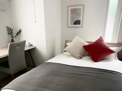 a bedroom with a bed with red and white pillows at Y's INN Nakai 005T in Tokyo