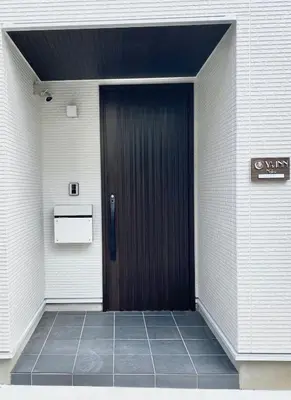 a black door in a white brick building at Y's INN Nakai 005T in Tokyo
