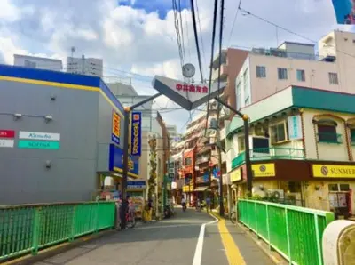 a city street with buildings and a green fence at Y's INN Nakai 005T in Tokyo