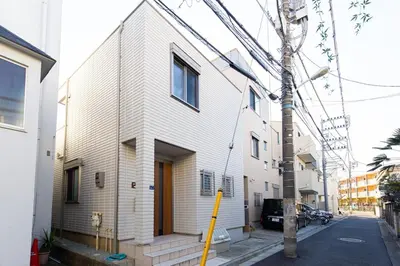 a white house with a yellow pole in front of it at Y's INN Nirinso 001T in Tokyo
