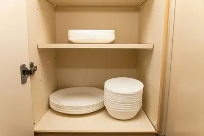 a cupboard with plates and bowls in it at Y's INN 有客 015T in Tokyo