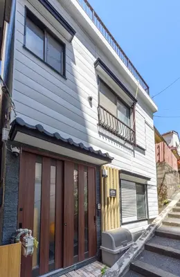 a house with wooden doors and a balcony at \u697d\u9038\u30b0\u30eb\u30fc\u30d7 \u65b0\u5bbf\u5fa1\u82d1 112t in Tokyo