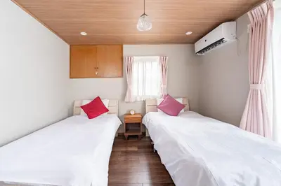 two beds in a room with white and pink pillows at Y's INN Tsutusji 014T in Tokyo