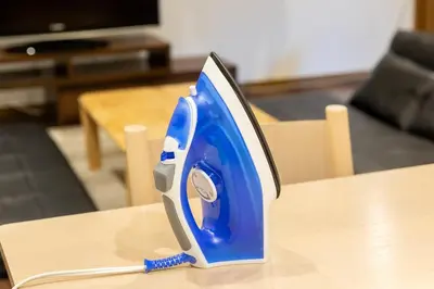 a blue and silver iron sitting on top of a table at Y's INN Tsutusji 014T in Tokyo