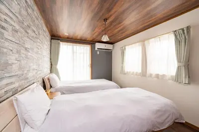 two beds in a room with a brick wall at Y's INN Tsutusji 014T in Tokyo