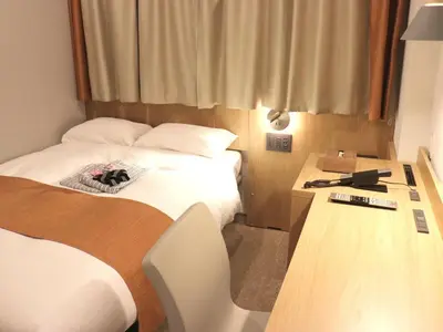 a small room with two beds and a night stand at Tokyo Inn - Vacation STAY 74555v in Tokyo
