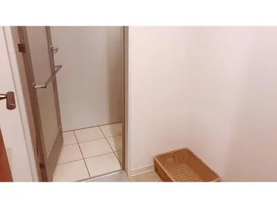 a bathroom with a door open and a basket at First Cabin Ichigaya 