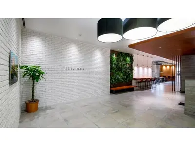 a lobby with a potted plant on a wall at First Cabin Ichigaya 