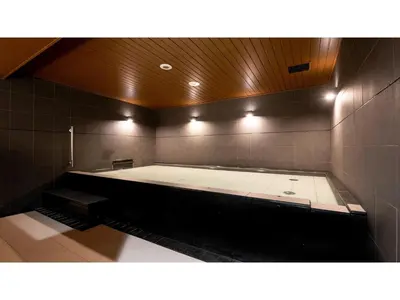 a large tub in a bathroom with lights on it at First Cabin Ichigaya 